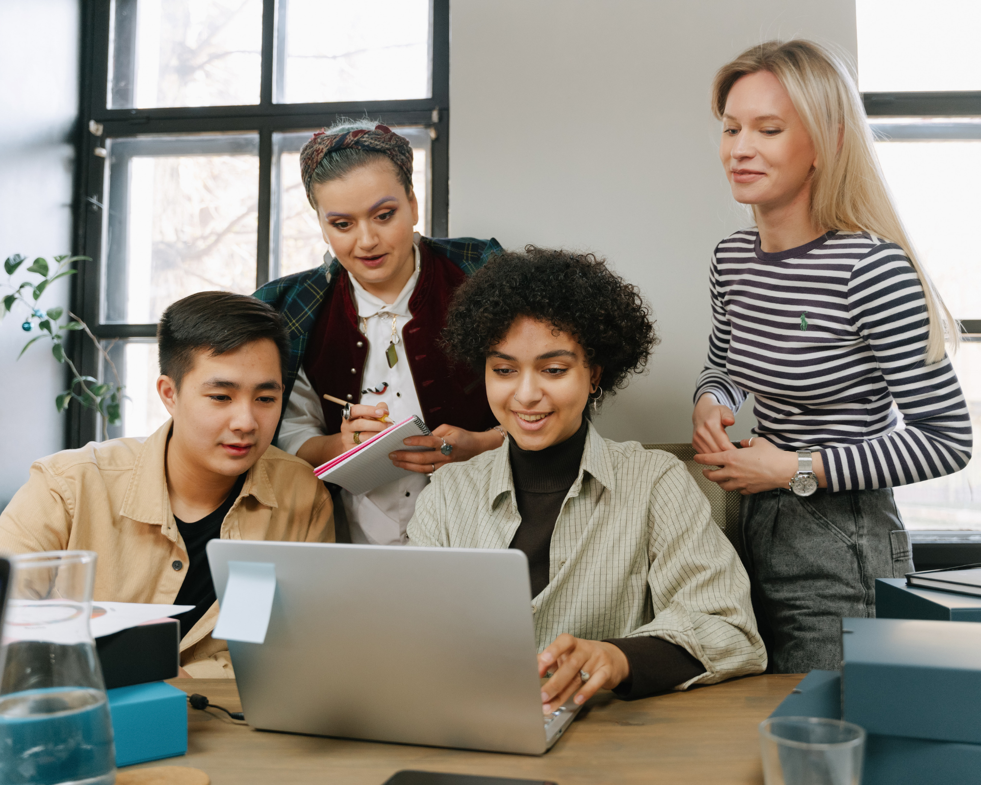 A team of mental health marketing specialists working together around a laptop